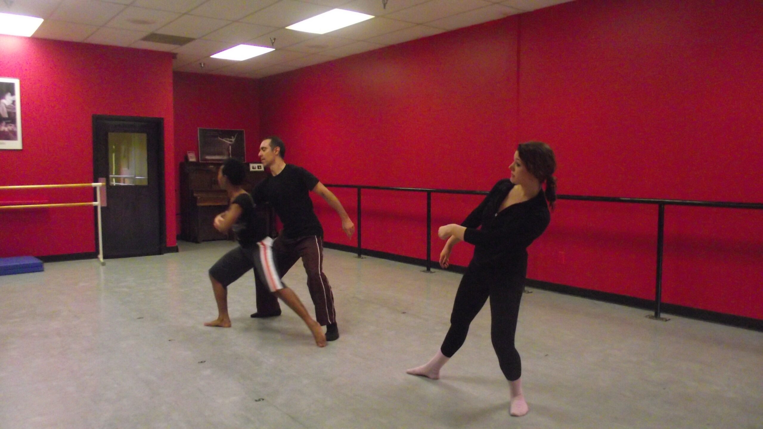 Three dancers rehearse in a dance studio